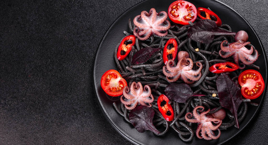 黑色海鲜意大利面配虾章鱼和黑色背景的贻贝地中海美食黑石板上的章图片
