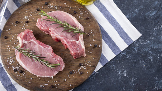生猪肉牛排配迷迭香料和橄榄油图片