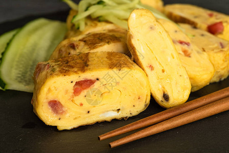 传统日本人滚动的煎蛋卷黄瓜和黑板上切黄瓜图片