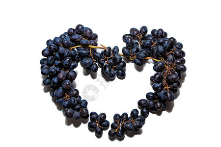 串在白色背景上孤立的黑葡萄由黑葡萄制成的心在白色图片