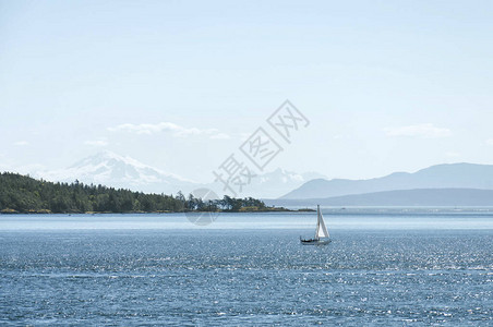 帆船在绿松石海水和山脉的背景下图片
