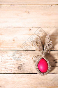 用粗麻布创意包裹的复活节极简主义扁平红鸡蛋位于天然木质背景顶视图图片
