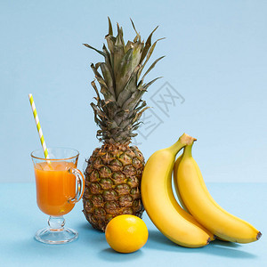 蓝色背景中的一杯果汁新鲜菠萝柠檬和香蕉图片