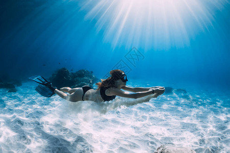 女子自由潜水员在沙海上空带白沙的滑翔伞图片