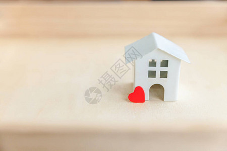 木制背景上有红心的微型玩具模型屋背景图片