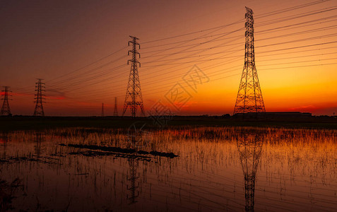 高压电塔和电线与夕阳的天空电线杆电力和能源的概念工业厂附近稻田图片