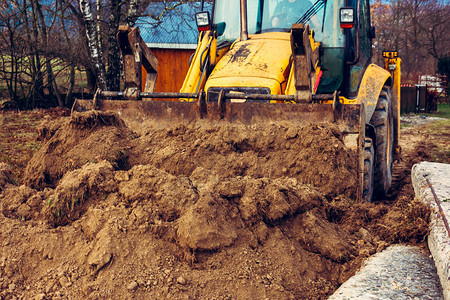 挖土机在农村街道上施工修筑道路图片