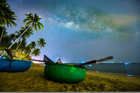 午夜风景与篮子船椰子棕榈树硅叶和银河在天空中度过美丽的夏夜图片