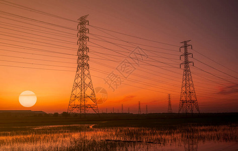 高压电塔和电线与夕阳的天空电线杆电力和能源的概念带电线缆的高压电网塔日落时美丽的大与背景图片