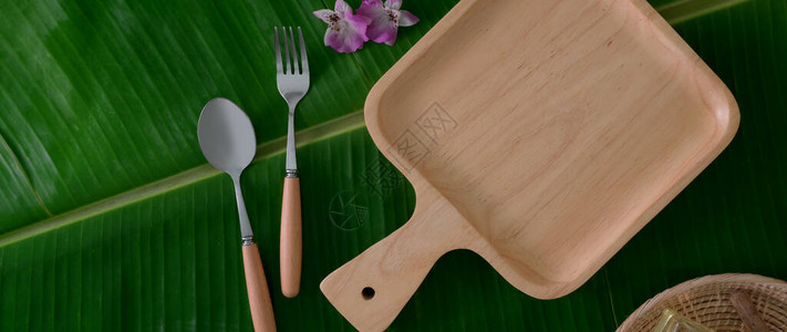 以香蕉叶背景生态友好型餐厅概念为背景的配勺子和民间众的木质图片