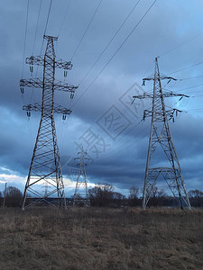 在城市郊区焦虑多云的天空背景下的金属输电塔高压塔荒凉的风景图片