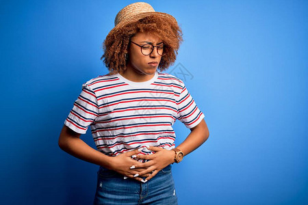 身着暑假帽子和带条纹T恤的非洲裔美籍女子因消化不良痛苦病痛不适而胃疼图片