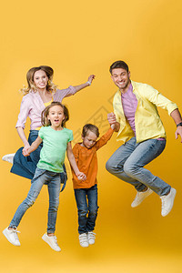 兴奋的家人在黄色上跳跃和牵手图片