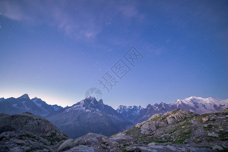 天亮时蓝星空下的白山峰图片