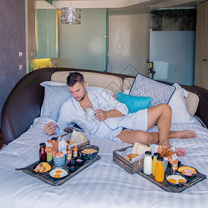 在豪华酒店客房的床上享用早餐图片