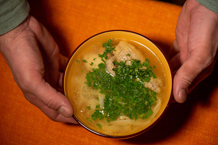 鸡肉面条汤橙色盘子里的橙色桌布上的鸡肉和面条汤美食摄影热菜肉汤配面条图片