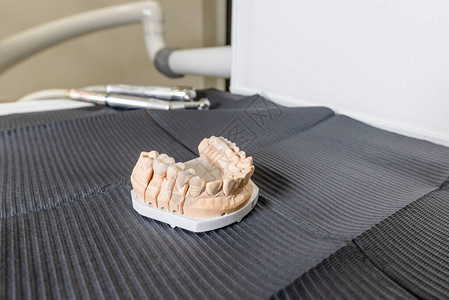 口腔化验室的桌子上摆着牙冠和名人图片