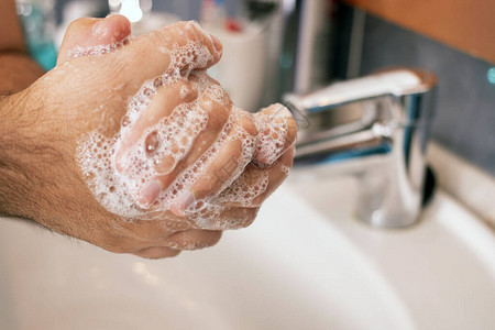 近距离观察用肥皂洗手以防止细菌图片
