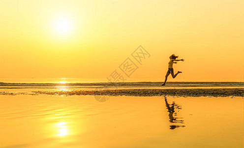 可爱的漂亮女人在早晨的阳光下在沙滩上奔跑图片