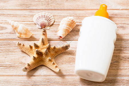 日幕瓶装贝壳和海星放在木桌平板上规图片