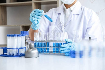 在生物技术实验室工作的科学家或医学实验室使用设备在临床实验室的玻璃瓶中混合图片