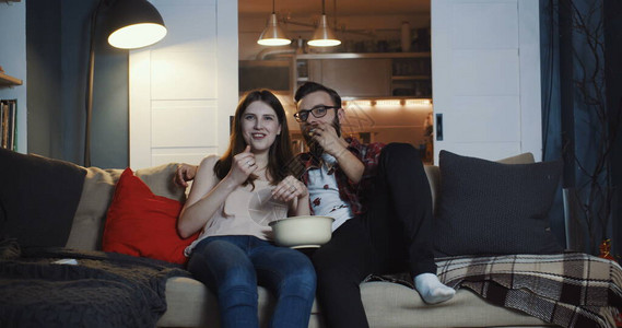 快乐的年轻休闲欧洲浪漫情侣在家看电视剧背景图片