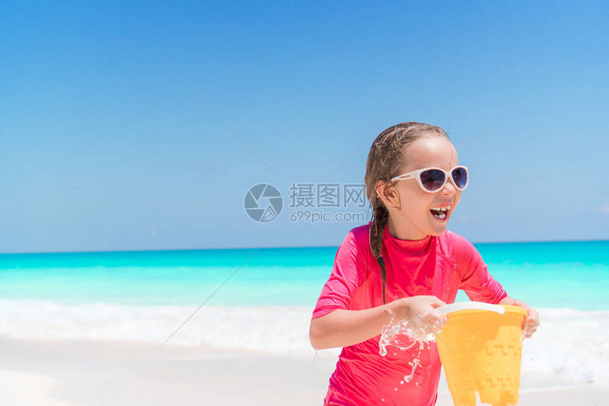 在海滩玩沙滩玩具的小快乐女孩图片