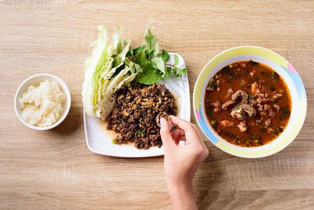当地北泰国食品辣薄煎猪肉沙拉LarbMooKua及牛肉肠咖喱香汤KaengO背景图片