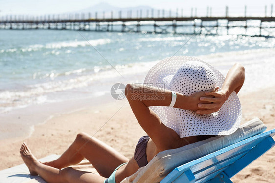 美丽的女人在热带旅游胜地的海滩上晒日光浴图片