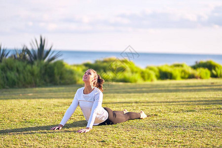 练瑜伽的年轻女运动员教练在公园教向图片