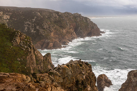 葡萄牙岩石角附近的海岸上的岩石背景图片