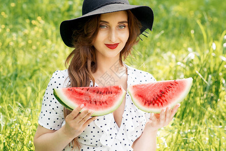 戴着黑帽子的漂亮年轻女子的画像拿着两片成熟的西瓜可爱的女孩拿着两片西图片