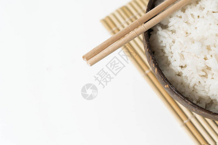 白米在白色背景的椰子碗中的白饭带大米和竹筷图片