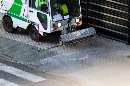 在人行道上工作的街道清洁机清扫车用加压水清洁人行道维图片