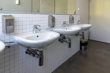 公共厕所中白色瓷砖下水道的白瓷水槽图片