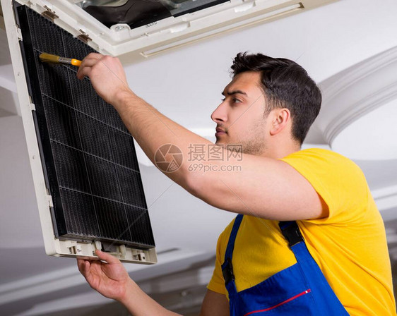 修理天花板空调机组的修理工图片