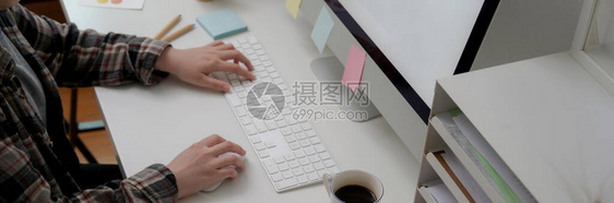 女平面设计师在办公桌上使用电脑与办公用品和咖图片