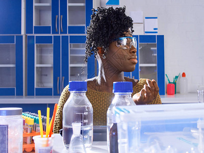 戴防护眼镜的年轻非洲女技术人员或科学家在现代研究实验室处理生物或图片