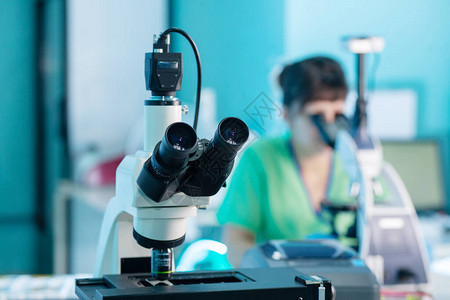 女专业医疗技术在研究实验室组织学或组织病理学中使用显微镜对细胞培养物进行显微镜分析以开发冠状疫苗以对抗co图片