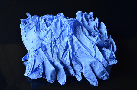 冠状的概念黑色背景的一次蓝色医用乳胶手套冠状流行期间的卫生规则图片