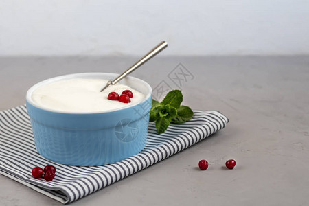 灰色背景的蓝色盘子上自制酸奶图片