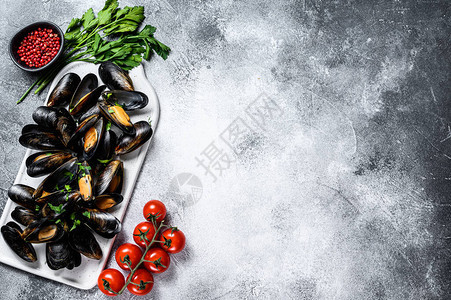 带壳的新鲜未煮过的贻贝用欧芹在番茄酱中烹饪的概念灰色背景顶视图图片