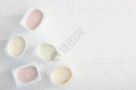 彩色桌顶视图的塑料杯中的酸奶插入文本的位置图片