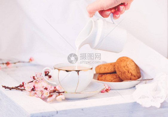 白瓷茶杯牛奶壶和新鲜的燕麦饼干英国早餐还有饮料美食和白桌布图片