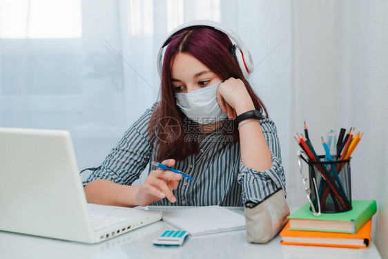 十几岁的女学生戴着带笔记本电脑的防医用口罩图片