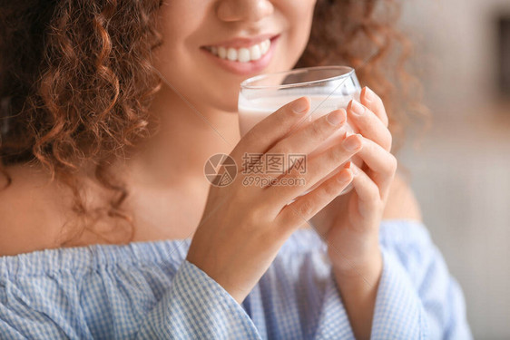 年轻女子在厨房里喝美味的酸奶特写图片