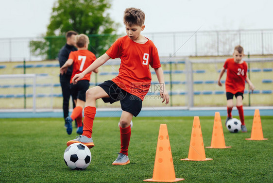 儿童足球队训练中的男孩子们用足球在户外练习在足球营为孩子们训练足球课小男孩提高运球技巧图片