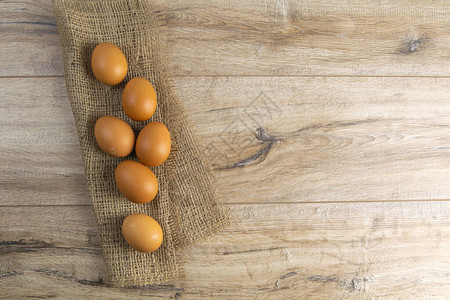 鸡蛋站在棕色木制桌子上的圆球上顶部视图片