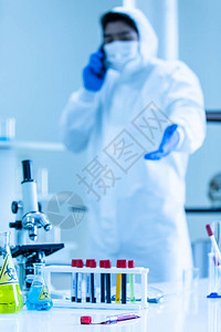 在覆盖物中的科学家对实验室工作的衣服进行消毒图片