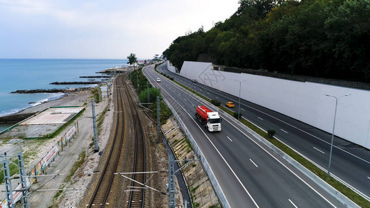 沿海岸和铁路的道路上行驶的卡车的鸟瞰图图片